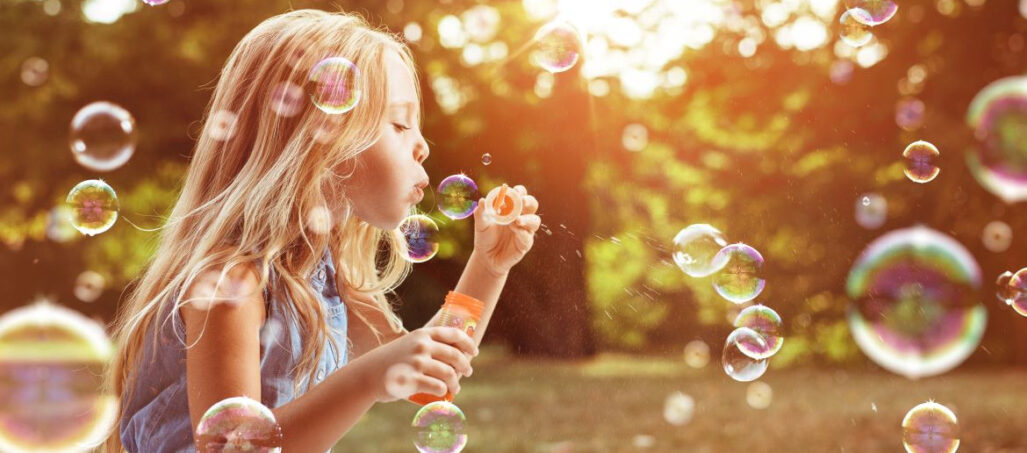 young girl blowing bubbles